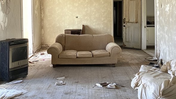 A drab empty living room that is no longer a home